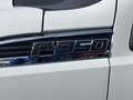 Close-up of a chrome badge displaying F-350 Super Duty on a white 2014 Ford F-350 truck