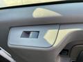 The interior door handle of a 2014 Chevrolet Express with a textured gray surface and a rectangular shape