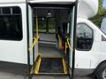 A 2020 Chevrolet Express bus with open double doors revealing a wheelchair accessible ramp and interior seating.