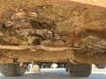 View of the underside of a 2010 Kubota F3990 showing a worn blade covered in debris and rust