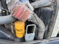 A close-up view of the engine components of a 2013 JCB 510-56 Loadall showing hoses and a yellow JCB oil filter