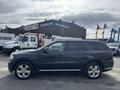 A 2015 Dodge Durango in dark gray with chrome accents and alloy wheels parked in a lot
