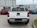 A white 2016 GMC Sierra 1500 pickup truck viewed from the rear with a chrome bumper and the GMC logo prominently displayed on the tailgate