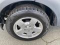 Close-up of a silver wheel and tire from a 2006 Land Rover LR3 featuring a five-spoke alloy rim and a rugged tire tread pattern