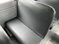 A row of worn black vinyl seats inside a 2015 Spartan school bus