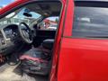 A red 2012 RAM 2500 truck with an open driver's side door showing the interior features including a steering wheel and dashboard