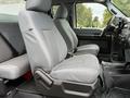 Interior of a 2015 Ford F-350 SD showing two gray cloth bucket seats with armrests and a console between them