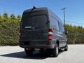 A 2017 Mercedes-Benz Sprinter van viewed from the rear with a sleek gray exterior and distinctive tail lights
