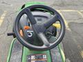 Steering wheel and control panel of a 2021 John Deere L Series S lawn tractor with levers and buttons for operation