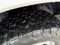 Close-up of a rugged tire from a 2017 Ford F-350 SD featuring deep treads and a textured surface with droplets of water highlighting its design
