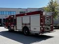 A red 2006 Emergency One Fire Truck with visible compartments and firefighting equipment on the side