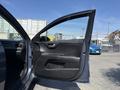 A 2018 Kia Rio5 with its driver's side door opened showing the interior panel and handle