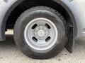 A close-up view of a silver wheel with a Goodyear Wrangler tire mounted on a 2020 Chevrolet Express