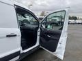 A 2017 Ford Transit Connect with an open driver's side door showing the black interior and dashboard