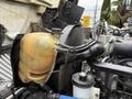 Close-up of a 2016 International CE300 engine compartment featuring a yellow coolant reservoir connected to various hoses and parts
