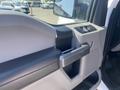 2017 Ford F-150 door interior featuring a large handle and control panel for window and mirror adjustments