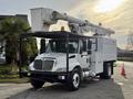 A white 2011 International 4300 bucket truck with an extended boom and a metal utility body equipped for maintenance and repair tasks