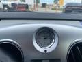 A dashboard clock in a 2007 Chrysler PT Cruiser, featuring a silver circular design with numbers and hands indicating the time