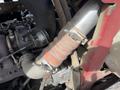 A close-up view of the exhaust system of a 2014 Toro Groundmaster 5910 showcasing a metallic pipe section with clamps and fittings