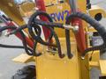Close-up of the hydraulic hoses and connections on a 2024 AGT KRW 23 Mini loader showcasing red and black braided hoses and metallic fittings