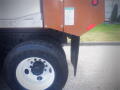 A 2016 International WorkStar 7500 heavy-duty truck with a brown side panel and white wheel showcasing a large tire and metal cab details