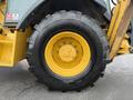 A 2011 John Deere 310SJ 4x4 Wheel Loader with an extended hoe and a 4 in 1 bucket featuring large black tires with yellow rims