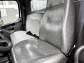 A grey driver's seat in a 2006 Freightliner M2 112 with a seatbelt and a sleek design