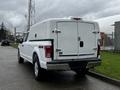 A white 2017 Ford F-150 truck with a matching canopy on its bed and a four-wheel drive emblem on the tailgate