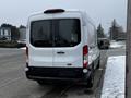 A white 2021 Ford Transit van viewed from the rear with large windows and a high roof