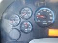 Dashboard of a 2014 International Durastar showing gauges for temperature oil pressure water temperature and RPM with warning lights illuminated