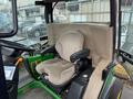 Interior view of a 2014 John Deere 1585 Terrain Cut showing a cushioned driver's seat with armrests and controls nearby