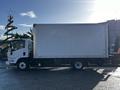 A white 2020 Isuzu NPR box truck with a flatbed design parked at an angle