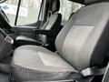 Two front seats of a 2021 Ford Transit with gray fabric upholstery and a textured pattern on the seat cushions