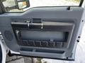 A close-up view of the interior door panel of a 2011 Ford F-450 SD featuring a textured handle and storage compartment