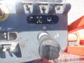 Control panel of a 2008 JLG Boom Lift featuring levers and a joystick for maneuvering the lift with labels indicating functionalities