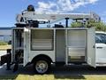 A 2023 Ford F-550 with an elevated bucket lift and open storage compartments showcasing organized tools and equipment