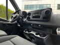 Interior view of a 2020 Mercedes-Benz Sprinter showing the steering wheel dashboard and central console with cup holders and audio controls
