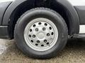 Close-up of a 2023 Ford Transit wheel featuring a silver rim and a black tire with tread design visible