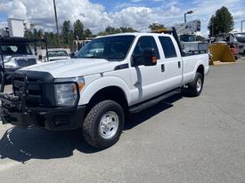 A white 2016 Ford F-350 Super Duty truck with a crew cab and utility bed parked on a concrete surface