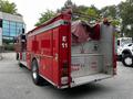 A red 1991 Sutphen Deluge fire truck with a covered hose compartment and safety signage on the side indicating to keep back 500 feet