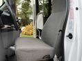 A gray driver's seat inside a 2014 Ford Econoline van with a steering wheel and dashboard partially visible