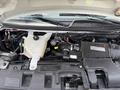 A 2017 Chevrolet Express engine compartment showing the coolant reservoir and various engine components with visible hoses and wiring