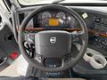 Interior view of a 2012 Volvo VNL truck featuring a steering wheel with controls a dashboard with gauges and a central display and cup holders