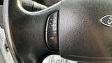 Close-up of the steering wheel controls of a 2007 Ford F-550 featuring a black textured finish and buttons labeled ON and OFF