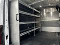 A 2020 Ford Transit van with metal shelving units installed inside the cargo area