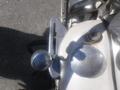 Close-up of a 1947 Harley-Davidson WL featuring a round chrome control knob and two polished metal parts on the motorcycle's frame