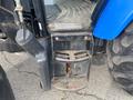 A close-up view of the steps and side panel of a 2016 New Holland T475 tractor showing wear and rust on the metal surfaces