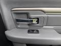 Close-up of the interior door handle of a 2018 RAM 1500 featuring a chrome lever and a button for window control