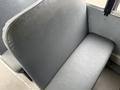 A gray vinyl bus seat with smooth surface and slight cushioning is shown from an overhead angle