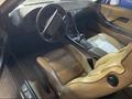 Interior of a 1983 Porsche 928 featuring a brown leather seat steering wheel and dashboard with gauges and controls